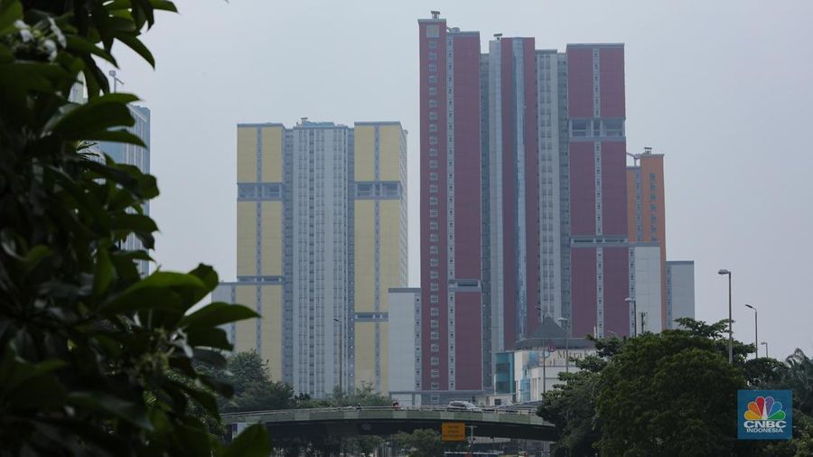 Pejalan kaki melintasi jembatan penyebrangan orang (JPO) dengan latar Wisma Atlet Kemayoran di Jakarta, Kamis (8/8/2024). (CNBC Indonesia/Faisal Rahman)