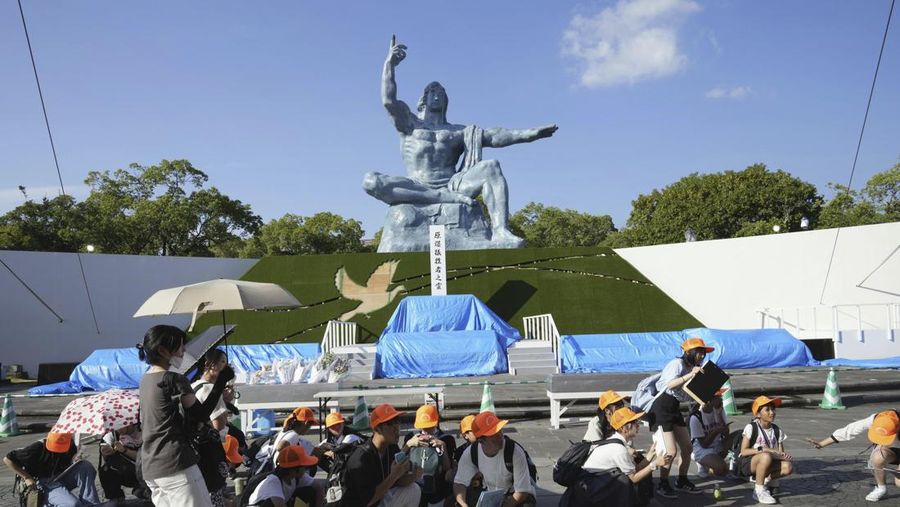 Pengunjung Taman Perdamaian berjongkok saat peringatan gempa bumi dikeluarkan di Nagasaki, Jepang bagian barat, Kamis, 8 Agustus 2024. (Kyodo News via AP)