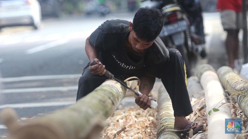 Perajin menyelesaikan pembuatan Pohon Pinang untuk Panjat dan tiang bendera bambu merah putih, di kawasan Manggarai, Jakarta, Kamis (8/8/2024). (CNBC Indonesia/Muhammad Sabki)