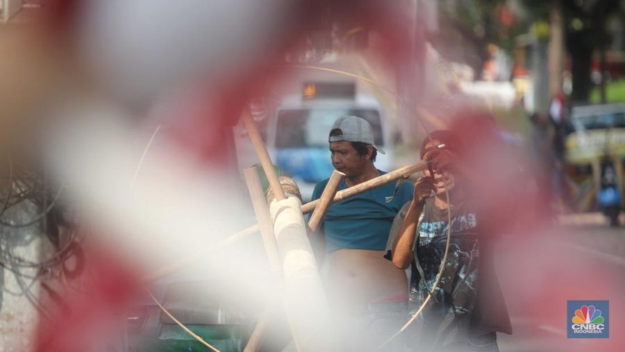 Perajin menyelesaikan pembuatan Pohon Pinang untuk Panjat dan tiang bendera bambu merah putih, di kawasan Manggarai, Jakarta, Kamis (8/8/2024). (CNBC Indonesia/Muhammad Sabki)