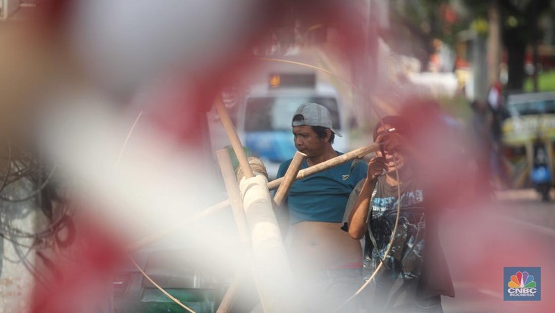 Perajin menyelesaikan pembuatan Pohon Pinang untuk Panjat dan tiang bendera bambu merah putih, di kawasan Manggarai, Jakarta, Kamis (8/8/2024). (CNBC Indonesia/Muhammad Sabki)
