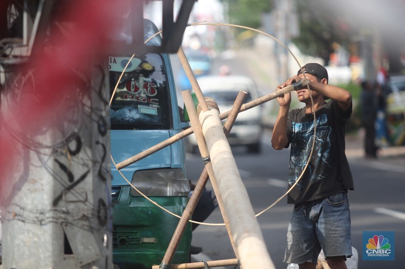 Perajin menyelesaikan pembuatan Pohon Pinang untuk Panjat dan tiang bendera bambu merah putih, di kawasan Manggarai, Jakarta, Kamis (8/8/2024). Perajin menyelesaikan pembuatan Pohon Pinang untuk Panjat dan tiang bendera bambu merah putih, di kawasan Manggarai, Jakarta, Kamis (8/8/2024). (CNBC Indonesia/Muhammad Sabki)