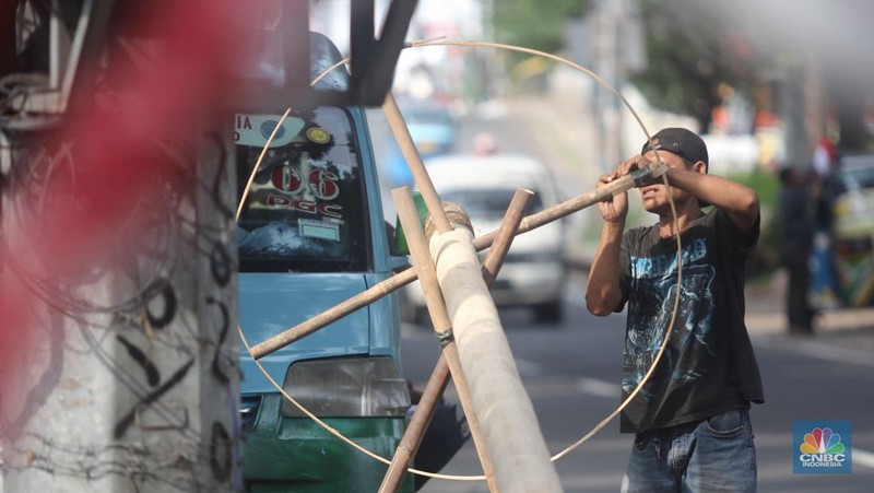 Perajin menyelesaikan pembuatan Pohon Pinang untuk Panjat dan tiang bendera bambu merah putih, di kawasan Manggarai, Jakarta, Kamis (8/8/2024). (CNBC Indonesia/Muhammad Sabki)