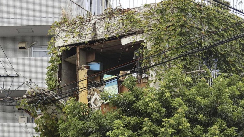 Pengunjung Taman Perdamaian berjongkok saat peringatan gempa bumi dikeluarkan di Nagasaki, Jepang bagian barat, Kamis, 8 Agustus 2024. (Kyodo News via AP)