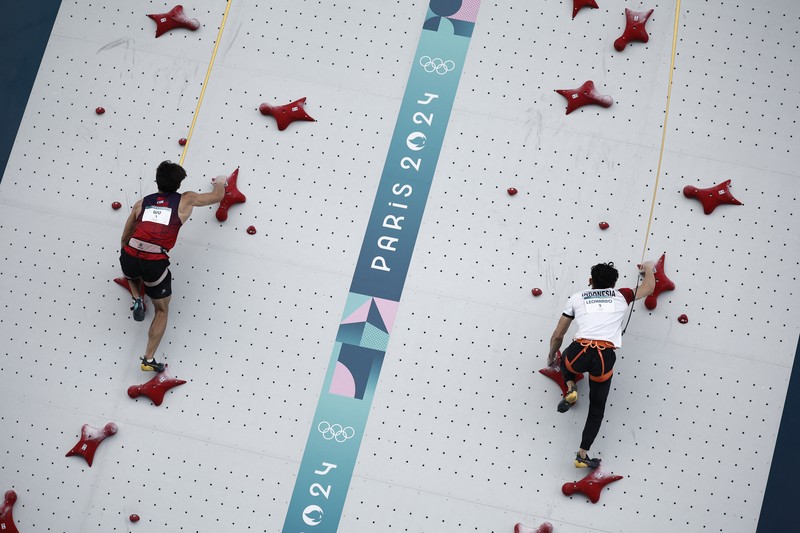 Veddriq Leonardo mengibarkan bendera Indonesia usai berhasil meraih medali emas pertama buat Indonesia usai mengalahkan Wu Peng pada final nomor speed panjat tebing di Le Boruget Climbing Venue, Kamis (8/8/2024). Veddriq Leonardo mengibarkan bendera Indonesia usai berhasil meraih medali emas pertama buat Indonesia usai mengalahkan Wu Peng pada final nomor speed panjat tebing di Le Boruget Climbing Venue, Kamis (8/8/2024). (REUTERS/Benoit Tessier)
