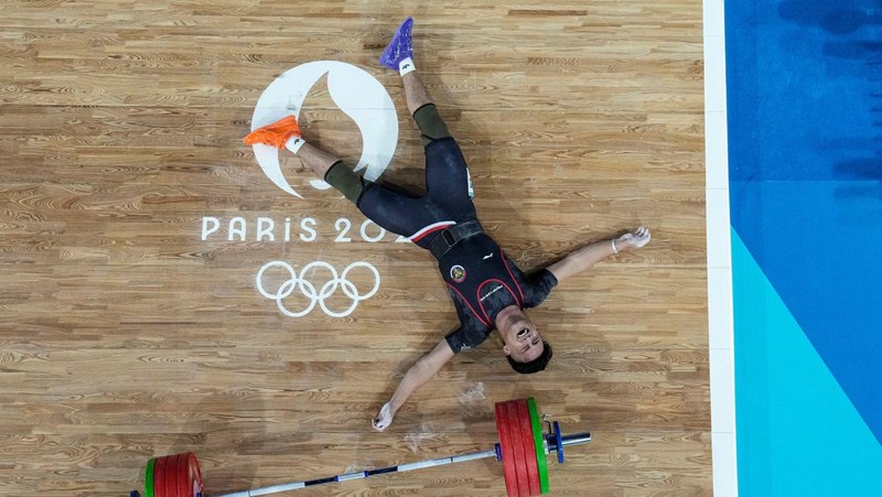 Atlet angkat besi Indonesia Rizki Juniansyah yang turun di nomor 73 kg pada Olimpiade Paris 2024 sukses menyabet medali emas. Hasil ini membuat Indonesia meraih 2 medali emas setelah di hari yang sama Veddriq Leonardo menyumbangkan emas di cabang panjat tebing. (REUTERS/Amanda Perobelli)
