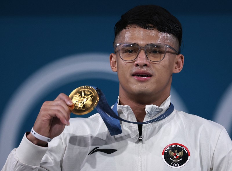 Atlet angkat besi Indonesia Rizki Juniansyah yang turun di nomor 73 kg pada Olimpiade Paris 2024 sukses menyabet medali emas. Hasil ini membuat Indonesia meraih 2 medali emas setelah di hari yang sama Veddriq Leonardo menyumbangkan emas di cabang panjat tebing. (REUTERS/Amanda Perobelli) Atlet angkat besi Indonesia Rizki Juniansyah yang turun di nomor 73 kg pada Olimpiade Paris 2024 sukses menyabet medali emas. Hasil ini membuat Indonesia meraih 2 medali emas setelah di hari yang sama Veddriq Leonardo menyumbangkan emas di cabang panjat tebing. (REUTERS/Amanda Perobelli)