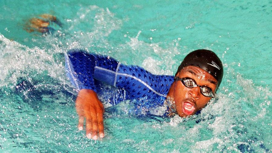 Overnight swimming sensation Eric Moussambani from Equatorial Guinea splashes his way down the pool as he completes a 50m demonstration at the Cook & Philip Pool in Sydney, Australia, Wednesday, September 20, 2000. Moussambani, one of the four-person swim team from Equatorial Guinea, was given the Speedo Fast.Skin bodysuit to test in the pool today. (AP Photo/Rob Griffith)