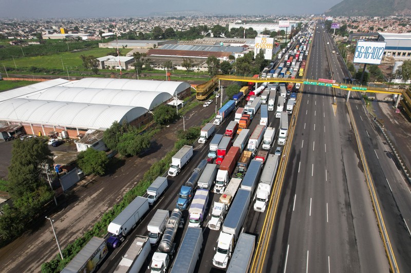 A drone view shows trailers and vehicles stranded as farmers from Santa Rita Tlahuapan block a highway to demand payment for the land expropriated for the construction of the expressway, in Tlahuapan, Puebla state, Mexico August 8, 2024. REUTERS/Diego Delgado