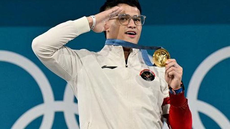 Gold medallist Indonesia's Rizki Juniansyah poses on the podium after the men's -73kg weightlifting event during the Paris 2024 Olympic Games at the South Paris Arena in Paris, on August 8, 2024. (Photo by Miguel MEDINA / AFP)