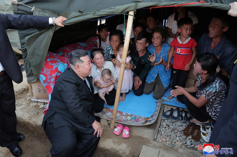 Pemimpin Korea Utara Kim Jong Un menyapa orang-orang saat berkunjung ke daerah yang terkena banjir di Kabupaten Uiju, Provinsi Pyongan Utara, Korea Utara, dalam foto yang dirilis 10 Agustus 2024. (KCNA via REUTERS)