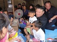 Potret Kim Jong Un Pangku Anak Korban & Duduk Bareng Korban Banjir