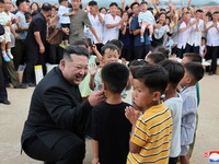 Pemimpin Korea Utara Kim Jong Un menyapa anak-anak saat berkunjung ke daerah yang terkena banjir di Kabupaten Uiju, Provinsi Pyongan Utara, Korea Utara, dalam foto yang dirilis 10 Agustus 2024. (KCNA via REUTERS)