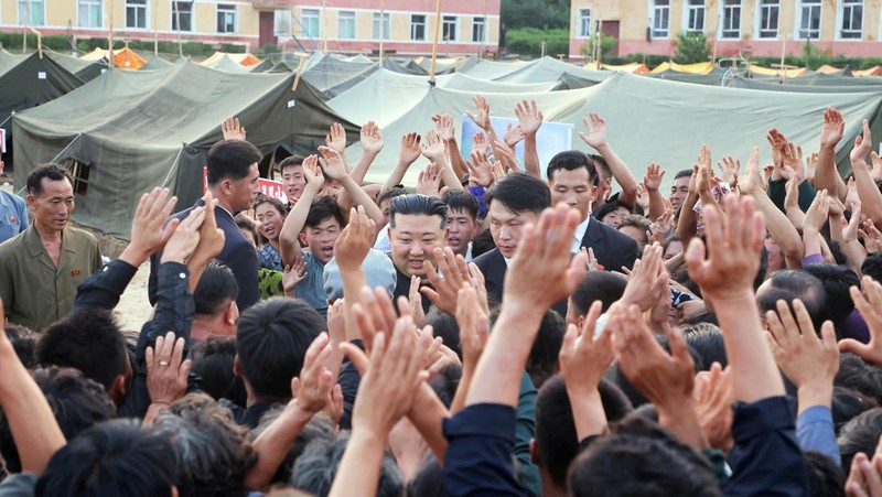Pemimpin Korea Utara Kim Jong Un menyapa orang-orang saat berkunjung ke daerah yang terkena banjir di Kabupaten Uiju, Provinsi Pyongan Utara, Korea Utara, dalam foto yang dirilis 10 Agustus 2024. (KCNA via REUTERS)