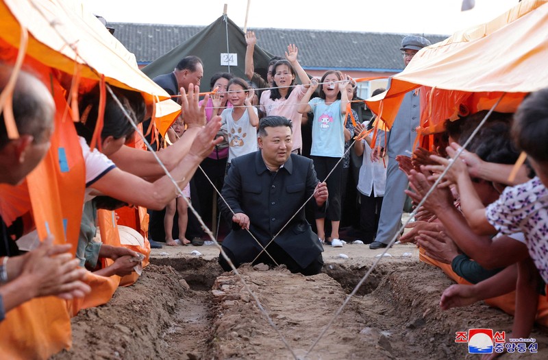 Pemimpin Korea Utara Kim Jong Un menyapa orang-orang saat berkunjung ke daerah yang terkena banjir di Kabupaten Uiju, Provinsi Pyongan Utara, Korea Utara, dalam foto yang dirilis 10 Agustus 2024. Pemimpin Korea Utara Kim Jong Un menyapa orang-orang saat berkunjung ke daerah yang terkena banjir di Kabupaten Uiju, Provinsi Pyongan Utara, Korea Utara, dalam foto yang dirilis 10 Agustus 2024. (KCNA via REUTERS)