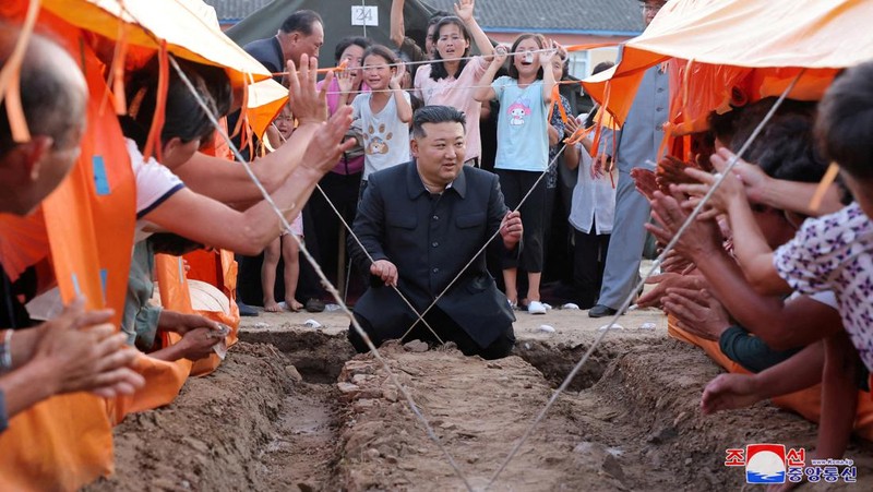 Pemimpin Korea Utara Kim Jong Un menyapa orang-orang saat berkunjung ke daerah yang terkena banjir di Kabupaten Uiju, Provinsi Pyongan Utara, Korea Utara, dalam foto yang dirilis 10 Agustus 2024. (KCNA via REUTERS)