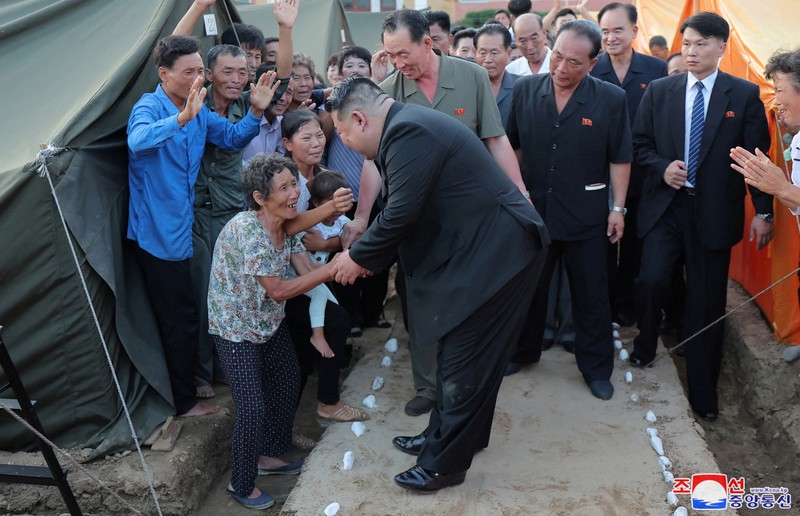Pemimpin Korea Utara Kim Jong Un menyapa orang-orang saat berkunjung ke daerah yang terkena banjir di Kabupaten Uiju, Provinsi Pyongan Utara, Korea Utara, dalam foto yang dirilis 10 Agustus 2024. Pemimpin Korea Utara Kim Jong Un menyapa orang-orang saat berkunjung ke daerah yang terkena banjir di Kabupaten Uiju, Provinsi Pyongan Utara, Korea Utara, dalam foto yang dirilis 10 Agustus 2024. (KCNA via REUTERS)