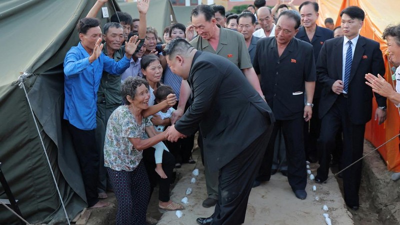Pemimpin Korea Utara Kim Jong Un menyapa orang-orang saat berkunjung ke daerah yang terkena banjir di Kabupaten Uiju, Provinsi Pyongan Utara, Korea Utara, dalam foto yang dirilis 10 Agustus 2024. (KCNA via REUTERS)