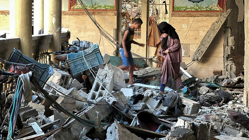 Warga Palestina memeriksa lokasi serangan Israel terhadap sekolah yang melindungi orang-orang terlantar, di tengah konflik Israel-Hamas, di Kota Gaza, 10 Agustus 2024. (REUTERS/Abed Sabah)
