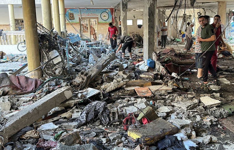 Warga Palestina memeriksa lokasi serangan Israel terhadap sekolah yang melindungi orang-orang terlantar, di tengah konflik Israel-Hamas, di Kota Gaza, 10 Agustus 2024. Warga Palestina memeriksa lokasi serangan Israel terhadap sekolah yang melindungi orang-orang terlantar, di tengah konflik Israel-Hamas, di Kota Gaza, 10 Agustus 2024. (REUTERS/Abed Sabah)