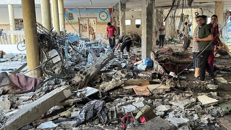 Warga Palestina memeriksa lokasi serangan Israel terhadap sekolah yang melindungi orang-orang terlantar, di tengah konflik Israel-Hamas, di Kota Gaza, 10 Agustus 2024. (REUTERS/Abed Sabah)