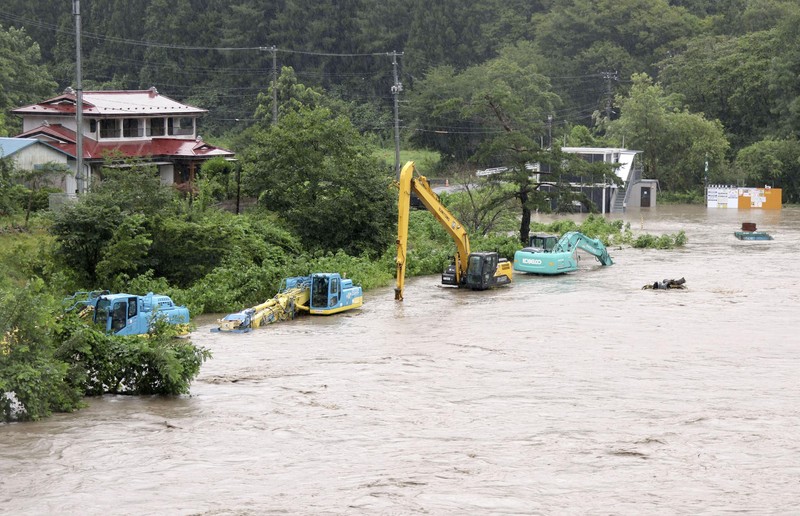 A man walks past a flooded road in the wake of 