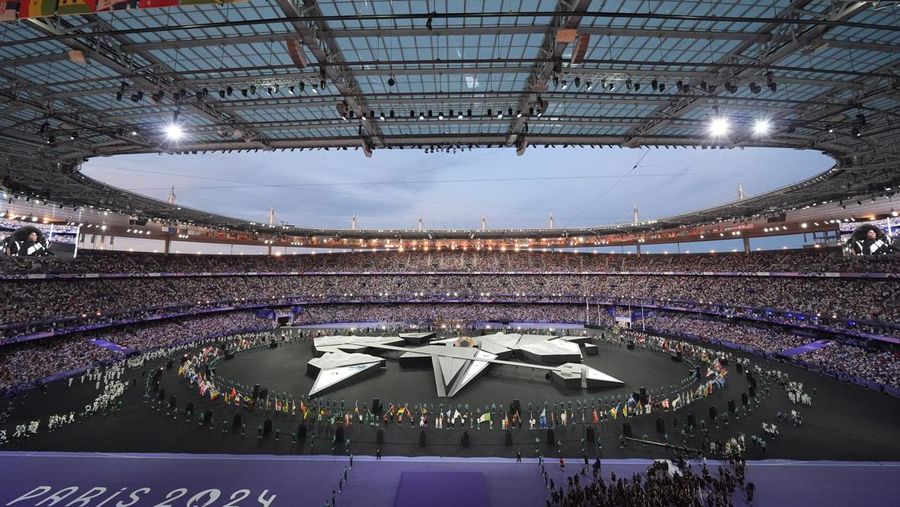 Para pembawa bendera berparade selama upacara penutupan Olimpiade Musim Panas 2024 di Stade de France, Minggu, 11 Agustus 2024, di Saint-Denis, Prancis. (AP Photo/David Goldman)