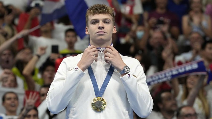 FILE - Leon Marchand of France, reacts after receiving his gold medal for the men's 200-meter individual medley final at the 2024 Summer Olympics, Friday, Aug. 2, 2024, in Nanterre, France. (AP Photo/Natacha Pisarenko, FIle)