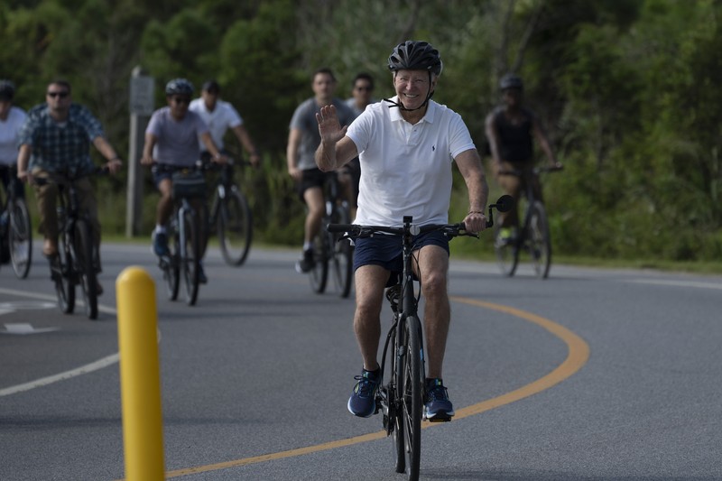 Presiden Joe Biden melambaikan tangan saat mengendarai sepedanya bersama agen Secret Service di Gordons Pond di Rehoboth Beach, Del., Minggu, 11 Agustus 2024. Presiden Joe Biden melambaikan tangan saat mengendarai sepedanya bersama agen Secret Service di Gordons Pond di Rehoboth Beach, Del., Minggu, 11 Agustus 2024. (AP Photo/Manuel Balce Ceneta)