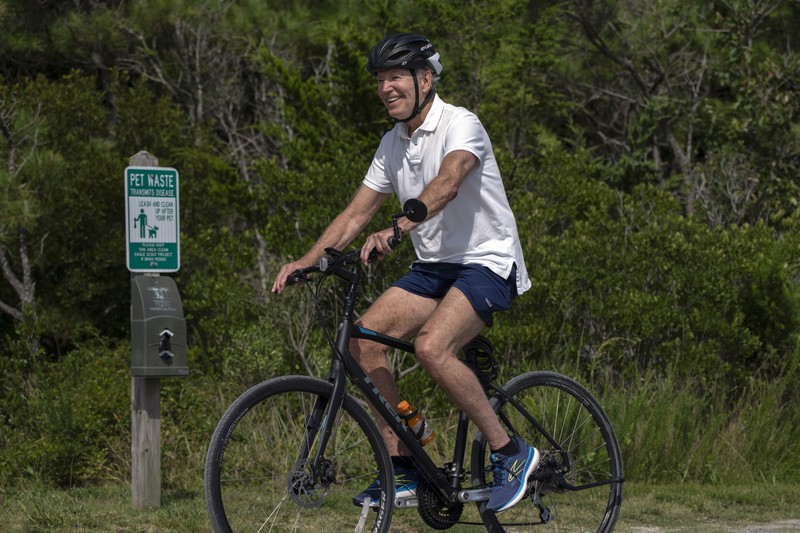 Presiden Joe Biden melambaikan tangan saat mengendarai sepedanya bersama agen Secret Service di Gordons Pond di Rehoboth Beach, Del., Minggu, 11 Agustus 2024. Presiden Joe Biden melambaikan tangan saat mengendarai sepedanya bersama agen Secret Service di Gordons Pond di Rehoboth Beach, Del., Minggu, 11 Agustus 2024. (AP Photo/Manuel Balce Ceneta)