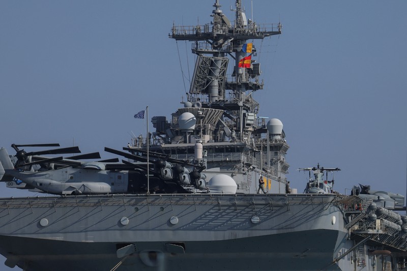 Seorang pria mengambil foto kapal serbu amfibi USS Wasp (LHD-1), saat berlabuh di pelabuhan Limassol, di tengah meningkatnya ketegangan di Timur Tengah, di Limassol, Siprus, 10 Agustus 2024. (REUTERS/Stelios Misinas)