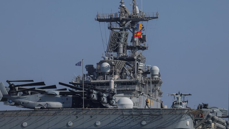 Seorang pria mengambil foto kapal serbu amfibi USS Wasp (LHD-1), saat berlabuh di pelabuhan Limassol, di tengah meningkatnya ketegangan di Timur Tengah, di Limassol, Siprus, 10 Agustus 2024. (REUTERS/Stelios Misinas)