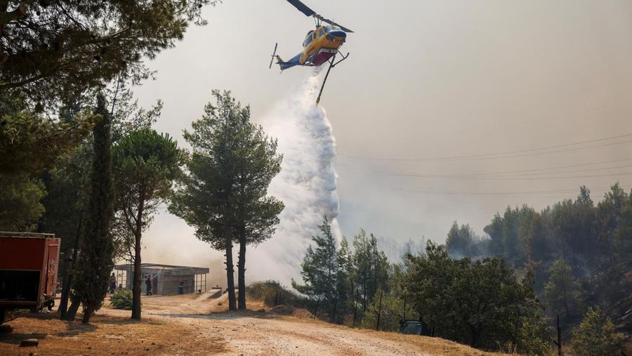 Sebuah bangunan sekolah menengah atas dan pusat kebugarannya terlihat terbakar saat kebakaran hutan melanda Nea Penteli, dekat Athena, Yunani, 12 Agustus 2024. (REUTERS/Alexandros Avramidis)