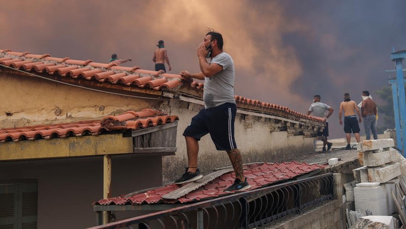 Sebuah bangunan sekolah menengah atas dan pusat kebugarannya terlihat terbakar saat kebakaran hutan melanda Nea Penteli, dekat Athena, Yunani, 12 Agustus 2024. (REUTERS/Alexandros Avramidis)