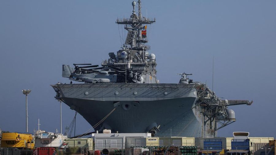 Seorang pria mengambil foto kapal serbu amfibi USS Wasp (LHD-1), saat berlabuh di pelabuhan Limassol, di tengah meningkatnya ketegangan di Timur Tengah, di Limassol, Siprus, 10 Agustus 2024. (REUTERS/Stelios Misinas)