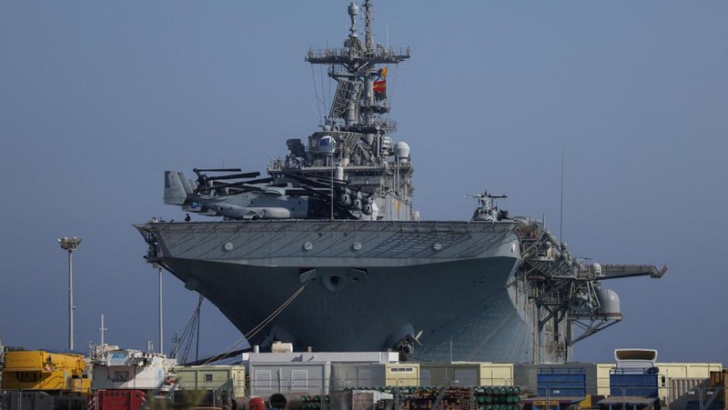 Seorang pria mengambil foto kapal serbu amfibi USS Wasp (LHD-1), saat berlabuh di pelabuhan Limassol, di tengah meningkatnya ketegangan di Timur Tengah, di Limassol, Siprus, 10 Agustus 2024. (REUTERS/Stelios Misinas)