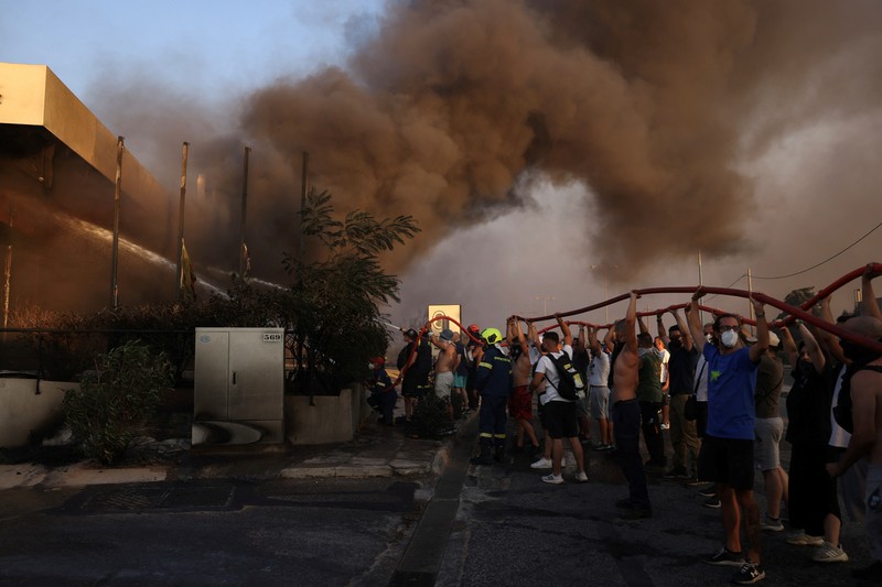 Sebuah bangunan sekolah menengah atas dan pusat kebugarannya terlihat terbakar saat kebakaran hutan melanda Nea Penteli, dekat Athena, Yunani, 12 Agustus 2024. Sebuah bangunan sekolah menengah atas dan pusat kebugarannya terlihat terbakar saat kebakaran hutan melanda Nea Penteli, dekat Athena, Yunani, 12 Agustus 2024. (REUTERS/Alexandros Avramidis)