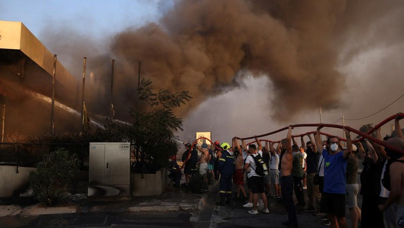 Sebuah bangunan sekolah menengah atas dan pusat kebugarannya terlihat terbakar saat kebakaran hutan melanda Nea Penteli, dekat Athena, Yunani, 12 Agustus 2024. (REUTERS/Alexandros Avramidis)