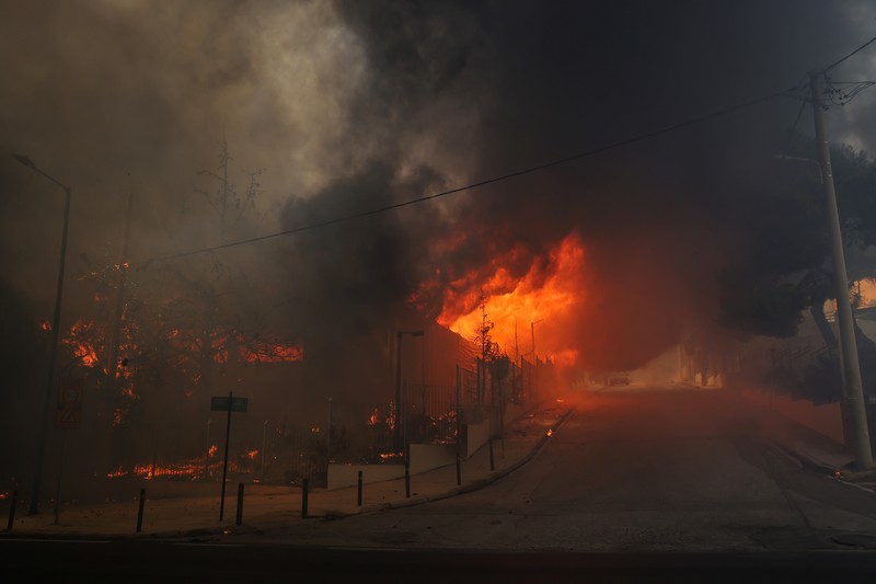Sebuah bangunan sekolah menengah atas dan pusat kebugarannya terlihat terbakar saat kebakaran hutan melanda Nea Penteli, dekat Athena, Yunani, 12 Agustus 2024. (REUTERS/Alexandros Avramidis)
