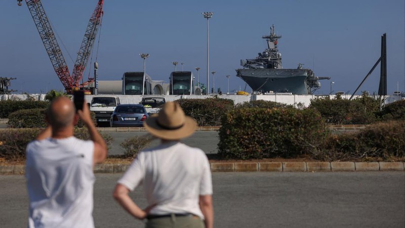 Seorang pria mengambil foto kapal serbu amfibi USS Wasp (LHD-1), saat berlabuh di pelabuhan Limassol, di tengah meningkatnya ketegangan di Timur Tengah, di Limassol, Siprus, 10 Agustus 2024. (REUTERS/Stelios Misinas)
