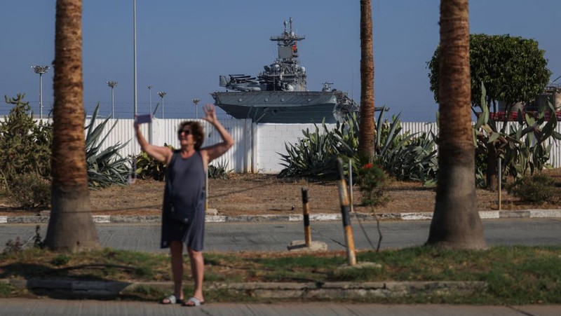 Seorang pria mengambil foto kapal serbu amfibi USS Wasp (LHD-1), saat berlabuh di pelabuhan Limassol, di tengah meningkatnya ketegangan di Timur Tengah, di Limassol, Siprus, 10 Agustus 2024. (REUTERS/Stelios Misinas)