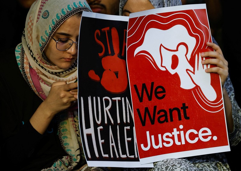 Para dokter muda memprotes pemerkosaan dan pembunuhan seorang petugas medis di Kolkata minggu lalu, dalam acara peringatan dengan menyalakan lilin di Hyderabad, India, Senin, 12 Agustus 2024. (AP Photo/Mahesh Kumar A.)