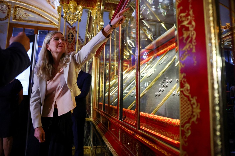 Seorang wanita mengambil gambar, saat barang-barang yang ditemukan dari pencurian permata di museum Gruenes Gewoelbe (Gudang Hijau) pada tahun 2019 dengan perkiraan nilai lebih dari 113 juta euro kembali dipamerkan setelah restorasi, di Dresden, Jerman, 13 Agustus 2024. (REUTERS/Nadja Wohlleben)