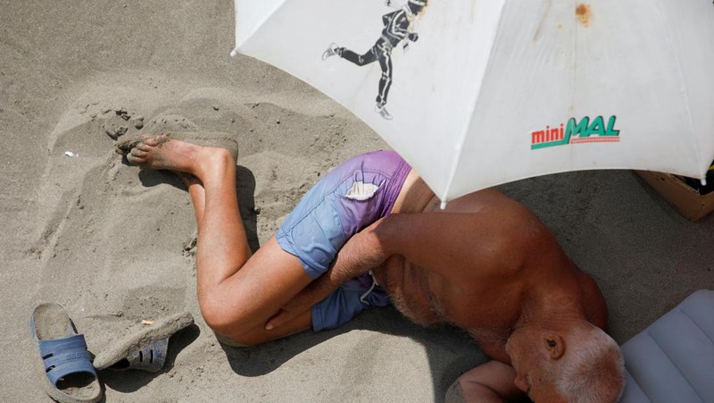 Orang-orang menikmati laut di perairan dangkal saat suhu mendekati 40 derajat Celsius di Ulcinj, Montenegro, 13 Agustus 2024. (REUTERS/Stevo Vasiljevic)