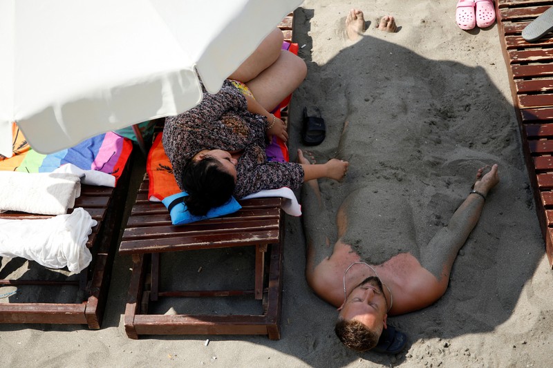 Orang-orang menikmati laut di perairan dangkal saat suhu mendekati 40 derajat Celsius di Ulcinj, Montenegro, 13 Agustus 2024. (REUTERS/Stevo Vasiljevic)
