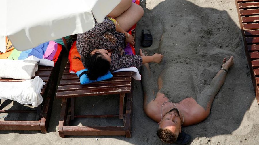 Orang-orang menikmati laut di perairan dangkal saat suhu mendekati 40 derajat Celsius di Ulcinj, Montenegro, 13 Agustus 2024. (REUTERS/Stevo Vasiljevic)