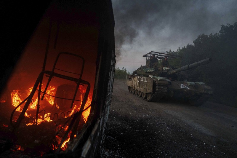 APTOPIX Ukraine Russia War A Ukrainian tank passes by a burning car near the Russian-Ukrainian border, Sumy region, Ukraine, Wednesday, Aug. 14, 2024. (AP Photo/Evgeniy Maloletka)
