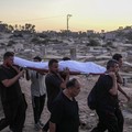 Palestinian mourners carry their loved one for burial at the cemetery in Deir al-Balah, Gaza Strip, Friday, Aug. 9, 2024. (AP Photo/Abdel Kareem Hana)