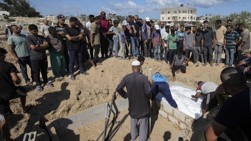 Palestinian mourners carry their loved one for burial at the cemetery in Deir al-Balah, Gaza Strip, Friday, Aug. 9, 2024. (AP Photo/Abdel Kareem Hana)