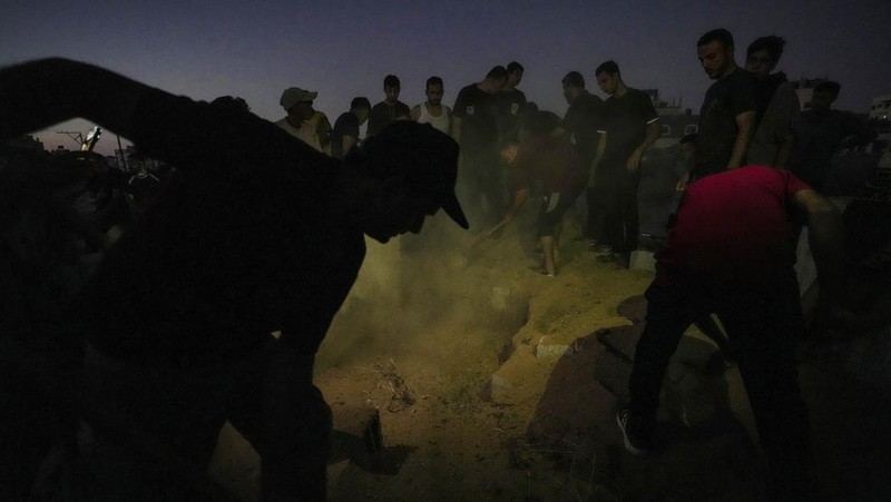 Palestinian mourners carry their loved one for burial at the cemetery in Deir al-Balah, Gaza Strip, Friday, Aug. 9, 2024. (AP Photo/Abdel Kareem Hana)